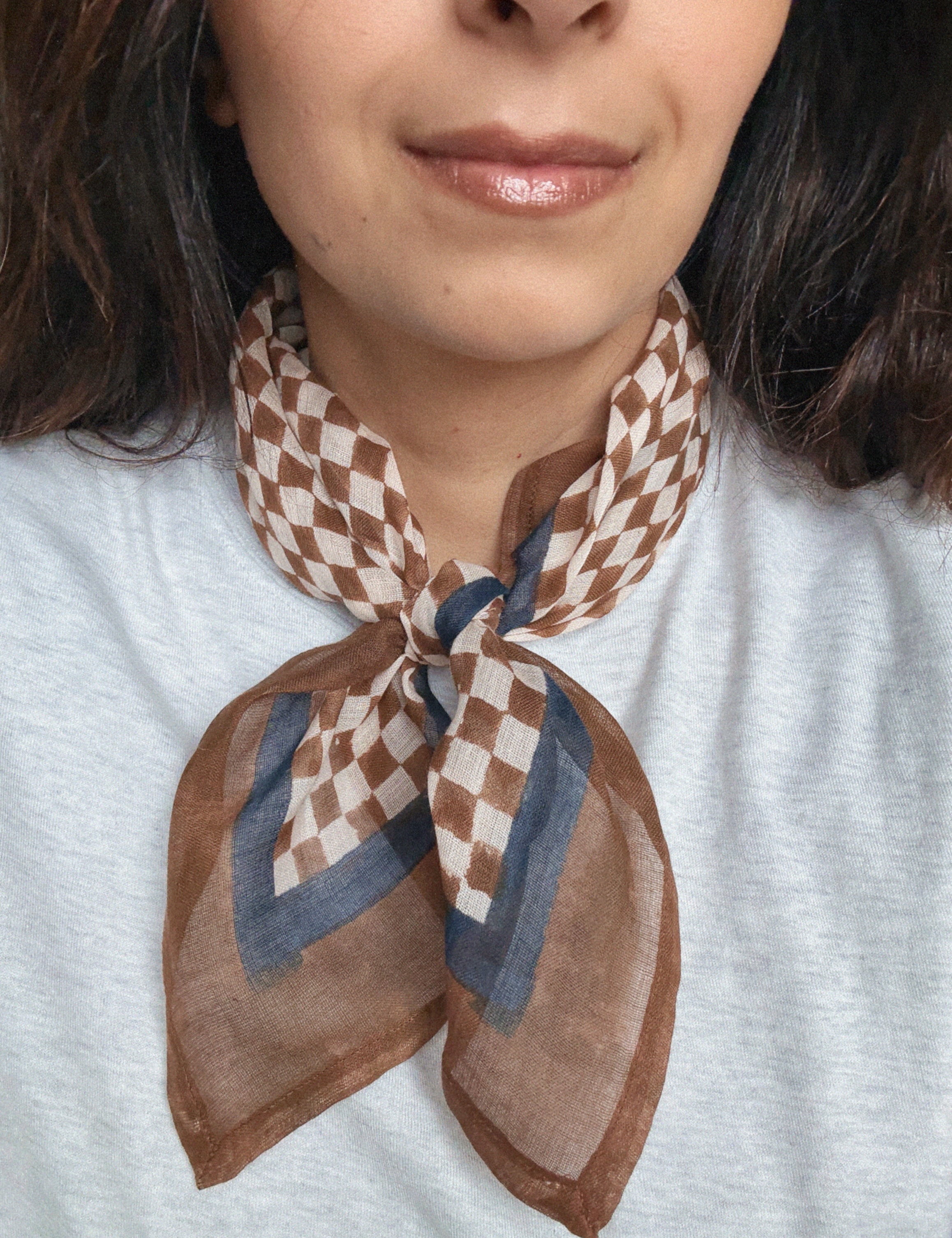 Person wearing a brown and beige checkered scarf