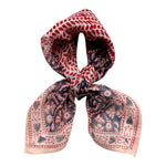 Decorative block printed bandana scarf with blue and red floral print, tied on white background