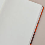 Open notebook with white pages on a beige background