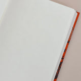 Open notebook with white pages on a beige background