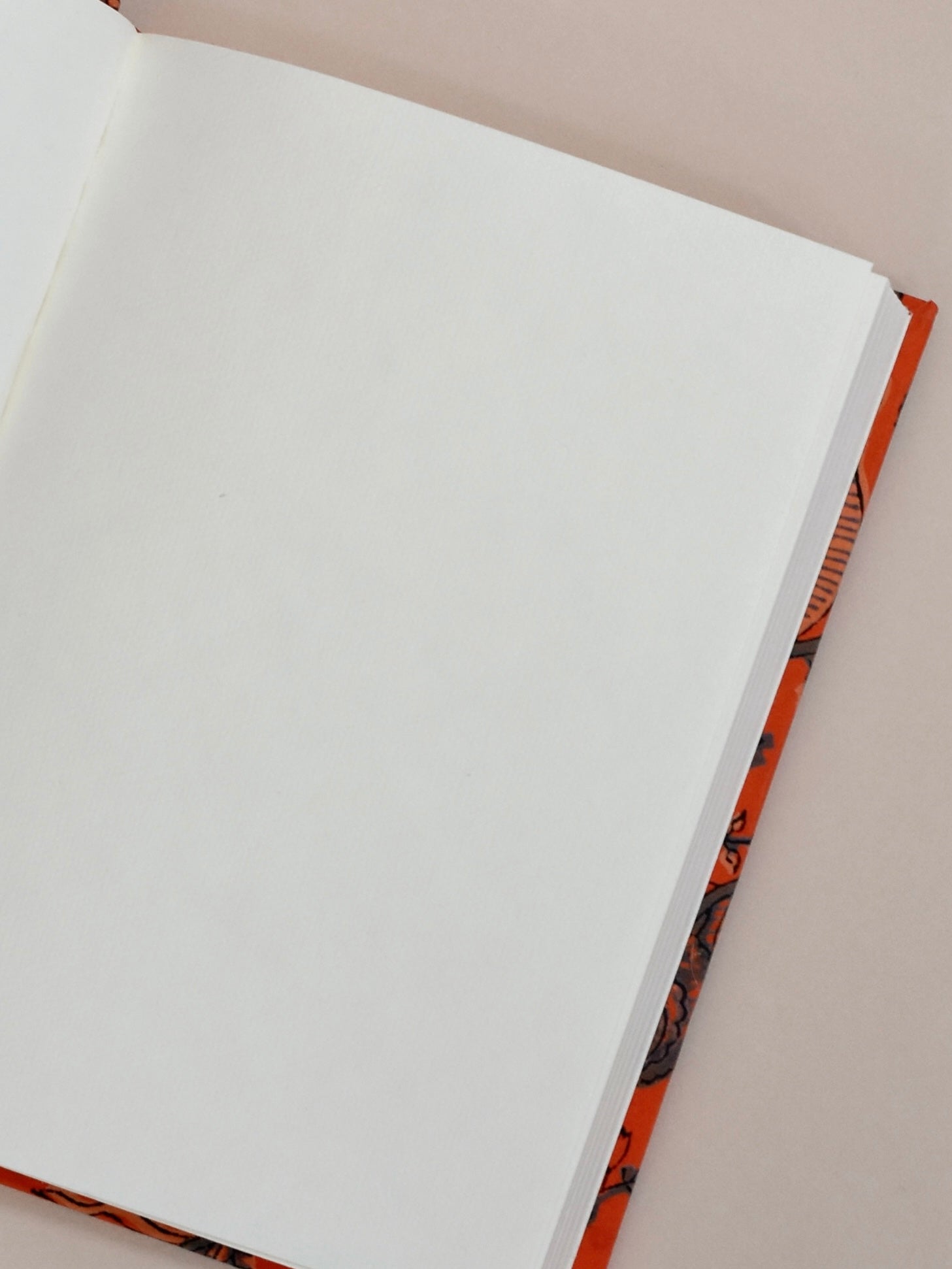 Open notebook with white pages on a beige background