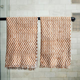 Block printed Dakota hand towels hanging on a black rod outside a shower