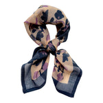 Blue and lavender floral printed bandana scarf, tied on a white background