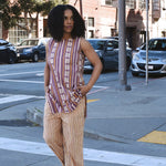 Woman in a striped sleeveless top and cropped pant set crossing a crosswalk