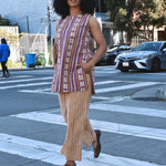 Woman in a striped sleeveless top and cropped pant set outfit crossing a street in an urban setting