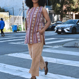Woman in a striped sleeveless top and cropped pant set outfit crossing a street in an urban setting