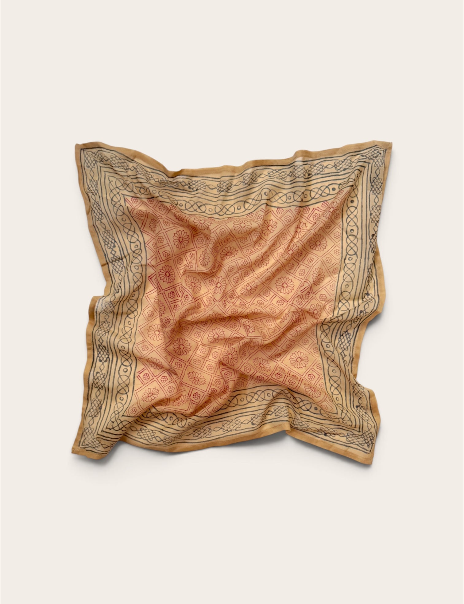 Terracotta Daisy Motif Bandana Scarf in lightweight cotton flat lay display featuring rust-red daisy lattice center and charcoal geometric border against off-white background