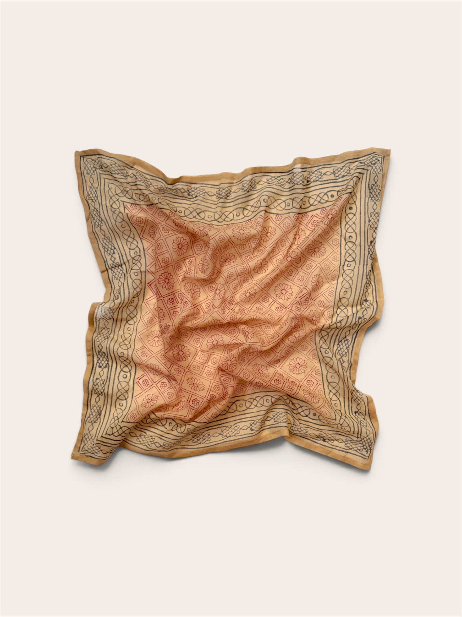 Terracotta Daisy Motif Bandana Scarf in lightweight cotton flat lay display featuring rust-red daisy lattice center and charcoal geometric border against off-white background