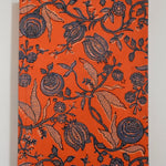 Floral patterned notebook with dark navy floral design on an orange background