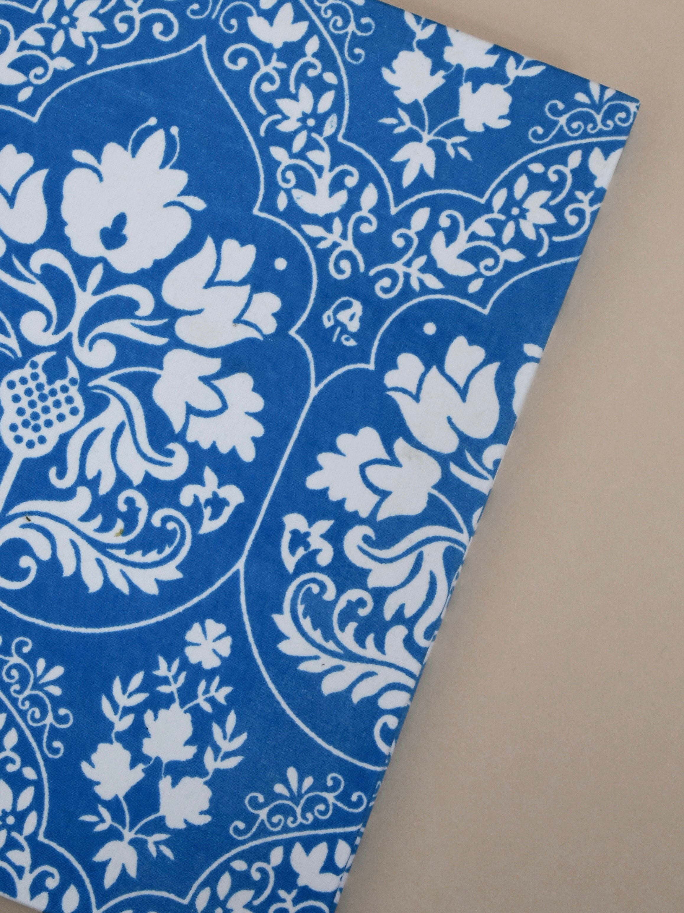Blue and white floral-patterned journal on a beige background