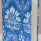 Blue notebook with white floral-patterned journal against a beige background