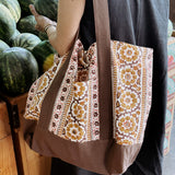 Woman wearing brown and gold floral printed tote bag while shopping for melons