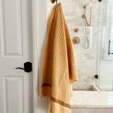 Feliz bath towel hanging on rod in the bathroom