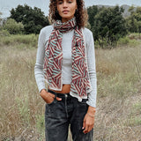 Woman wearing block printed Layla georgette scarf around the neck, paired with grey long sleeve and black jeans. Woman is standing outside.