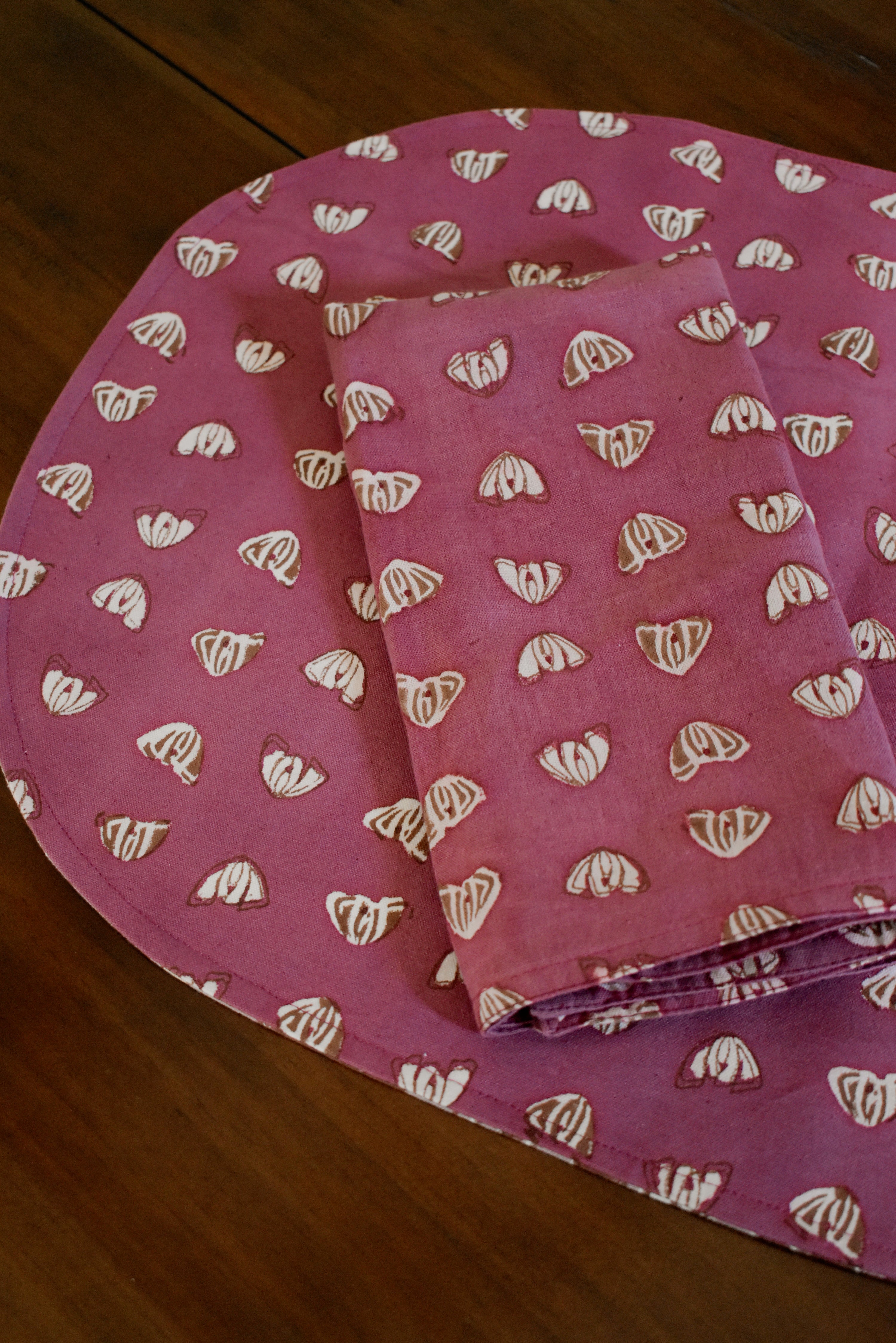 Purple floral printed placemats with matching table napkin on a wooden table