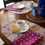 Dining table with floral printed placemats, napkins and tea cups/plates