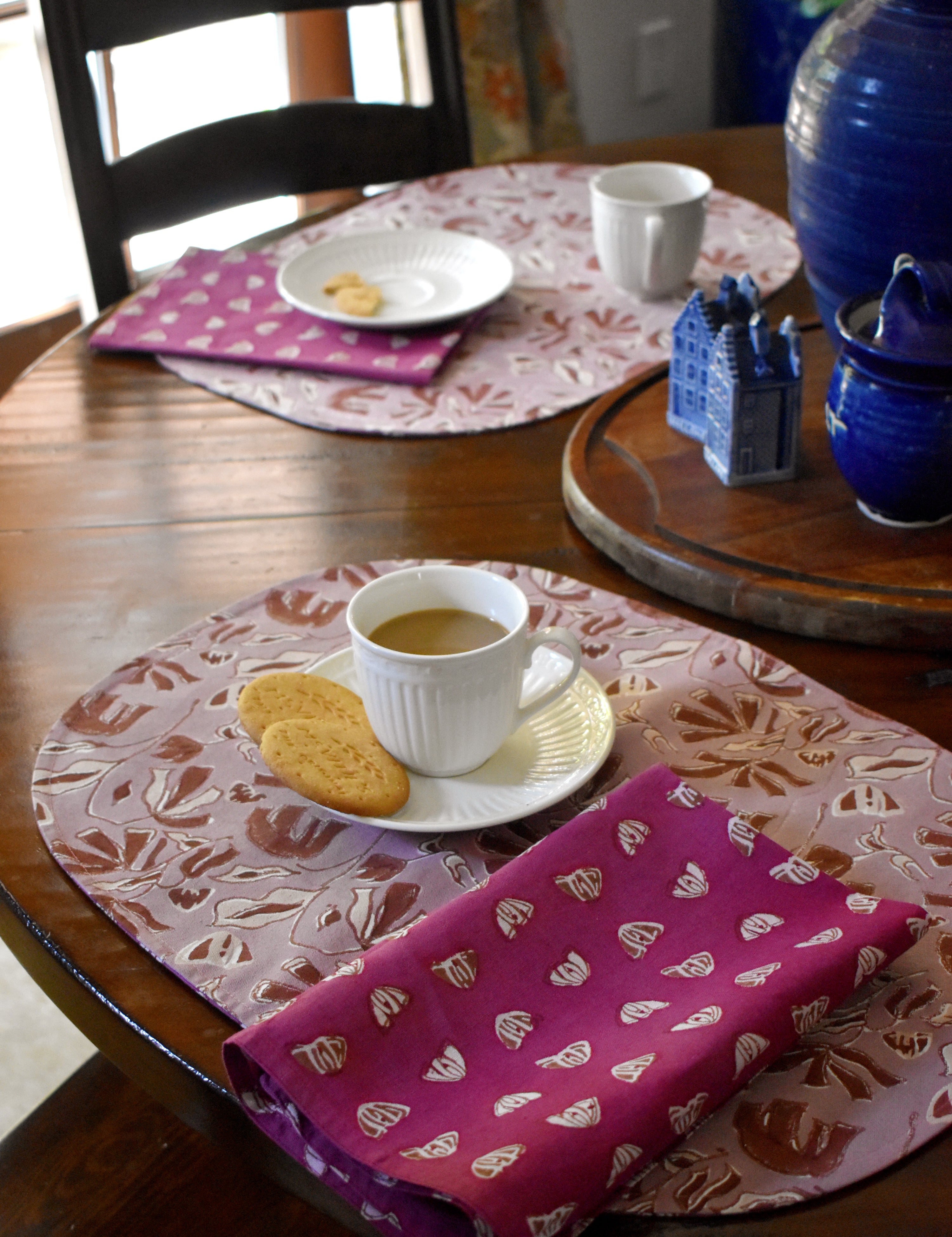 Dining table with floral printed placemats, napkins and tea cups/plates