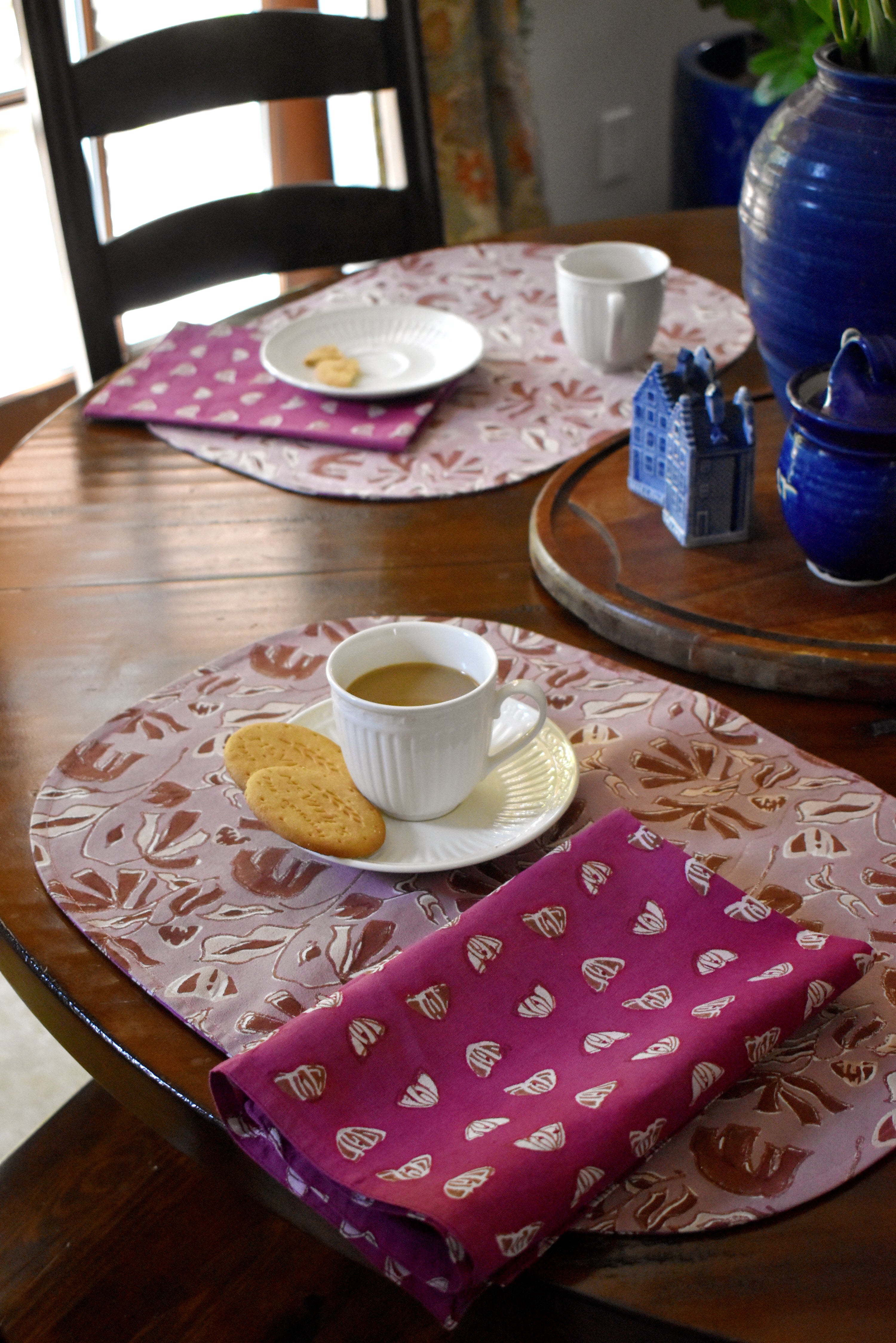 Dining table with floral printed placemats, napkins and tea cups/plates