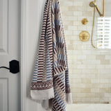 Block printed striped khadi bath towel hanging on a shower hook