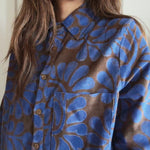 Person wearing a blue and brown floral patterned corduroy shirt