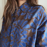 Person wearing a blue and brown floral patterned corduroy shirt