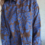 Blue and brown patterned shirt worn by a person against a plain background
