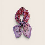 Multicolored purple and pink patterned scarf on a light beige background