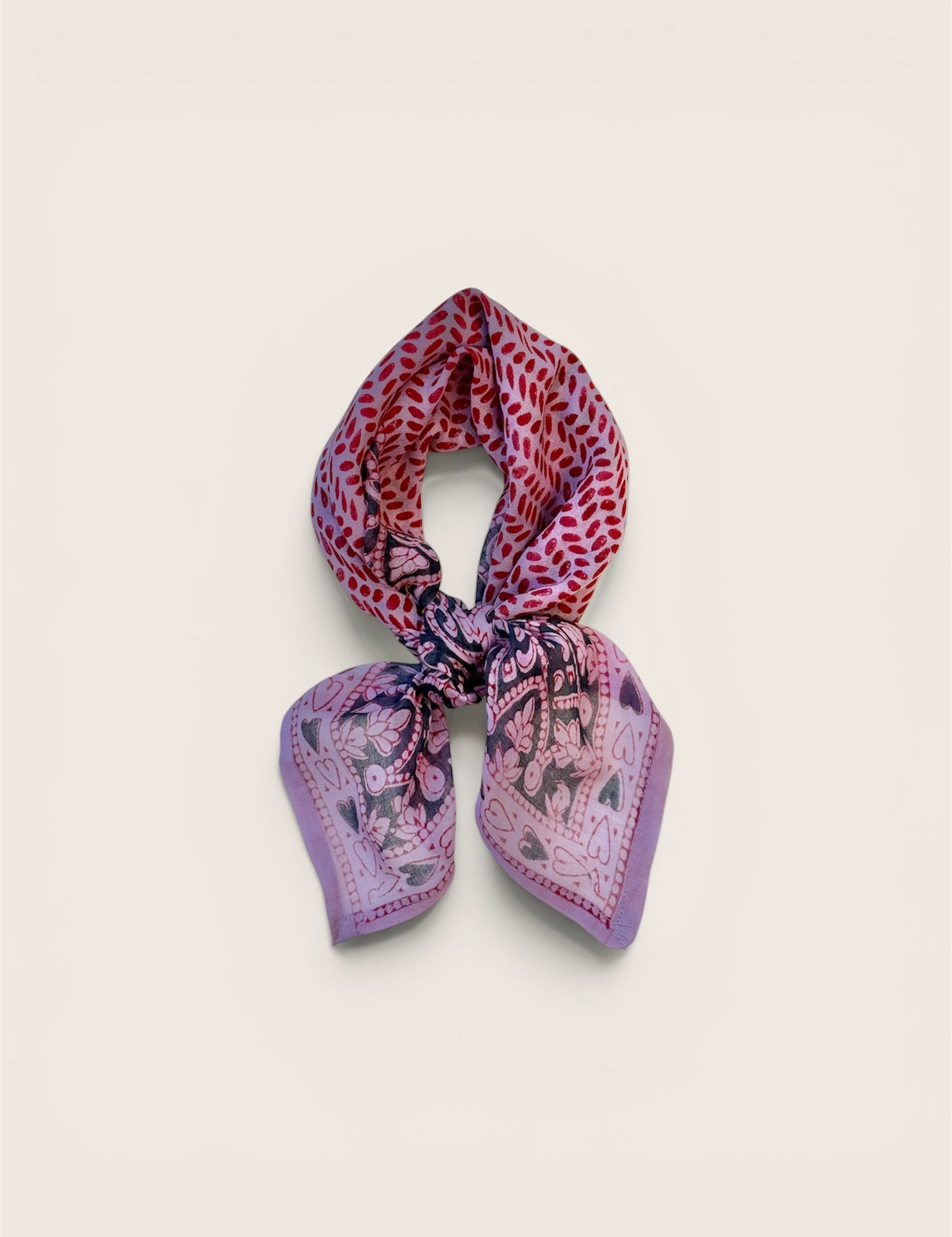 Multicolored purple and pink patterned scarf on a light beige background