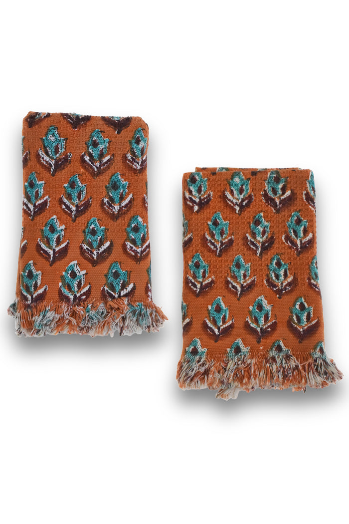 Two Dakota block printed hand towels folded and placed next to each other on a white background