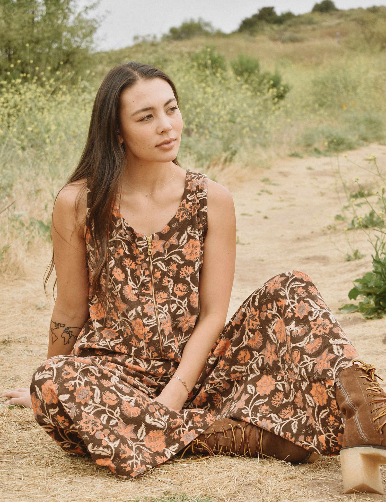 Woman wearing block printed, floral printed Corduroy Jumpsuit, sitting in nature