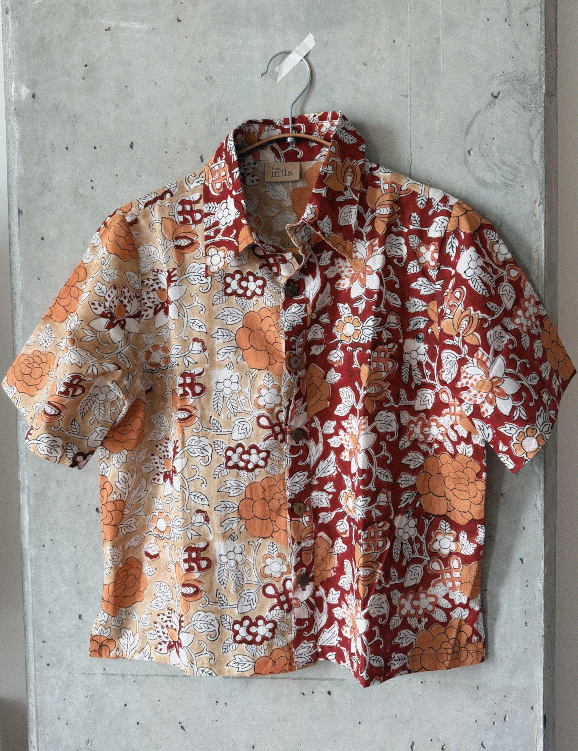 Floral patterned shirt hanging on a concrete wall
