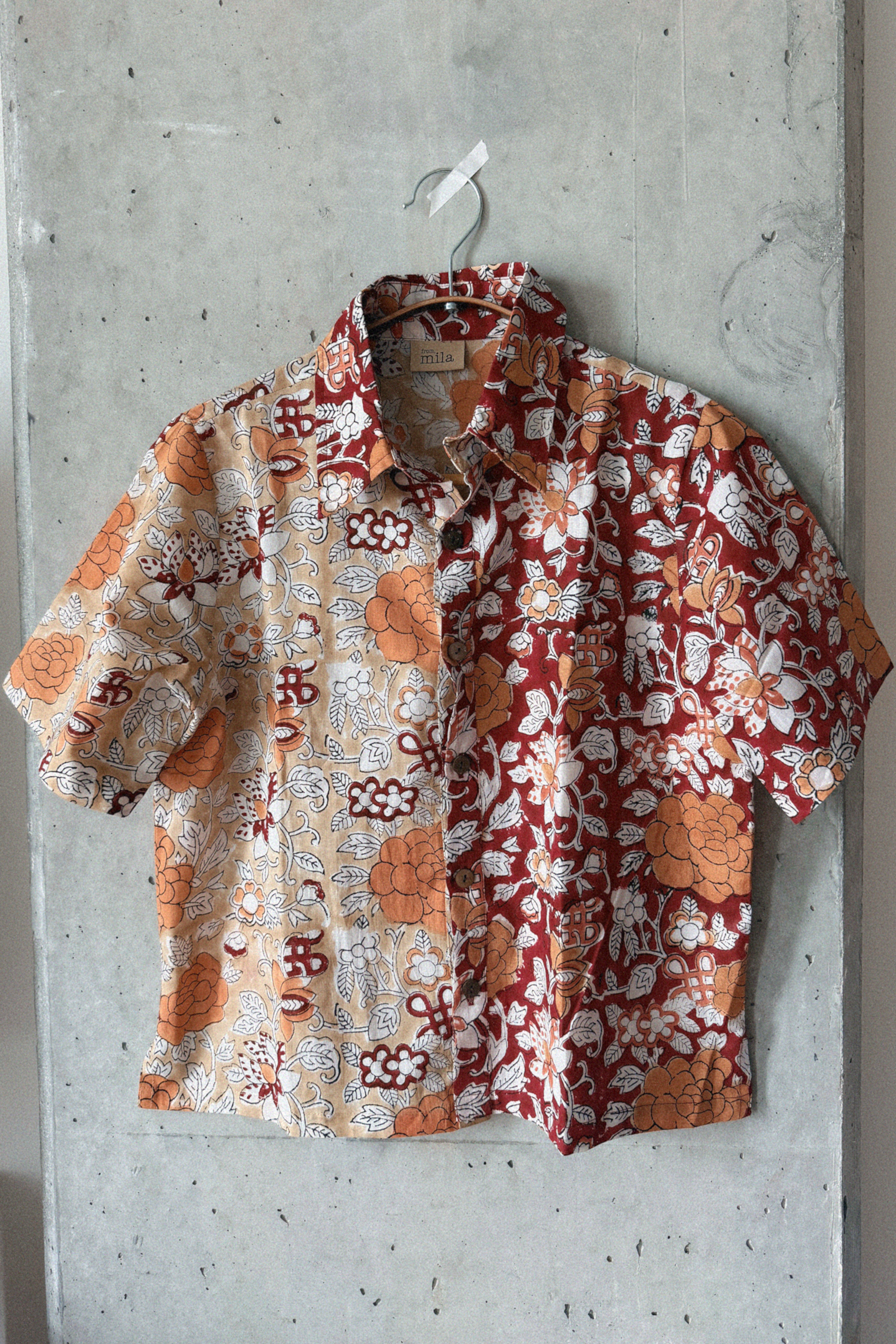 Floral patterned shirt hanging on a concrete wall