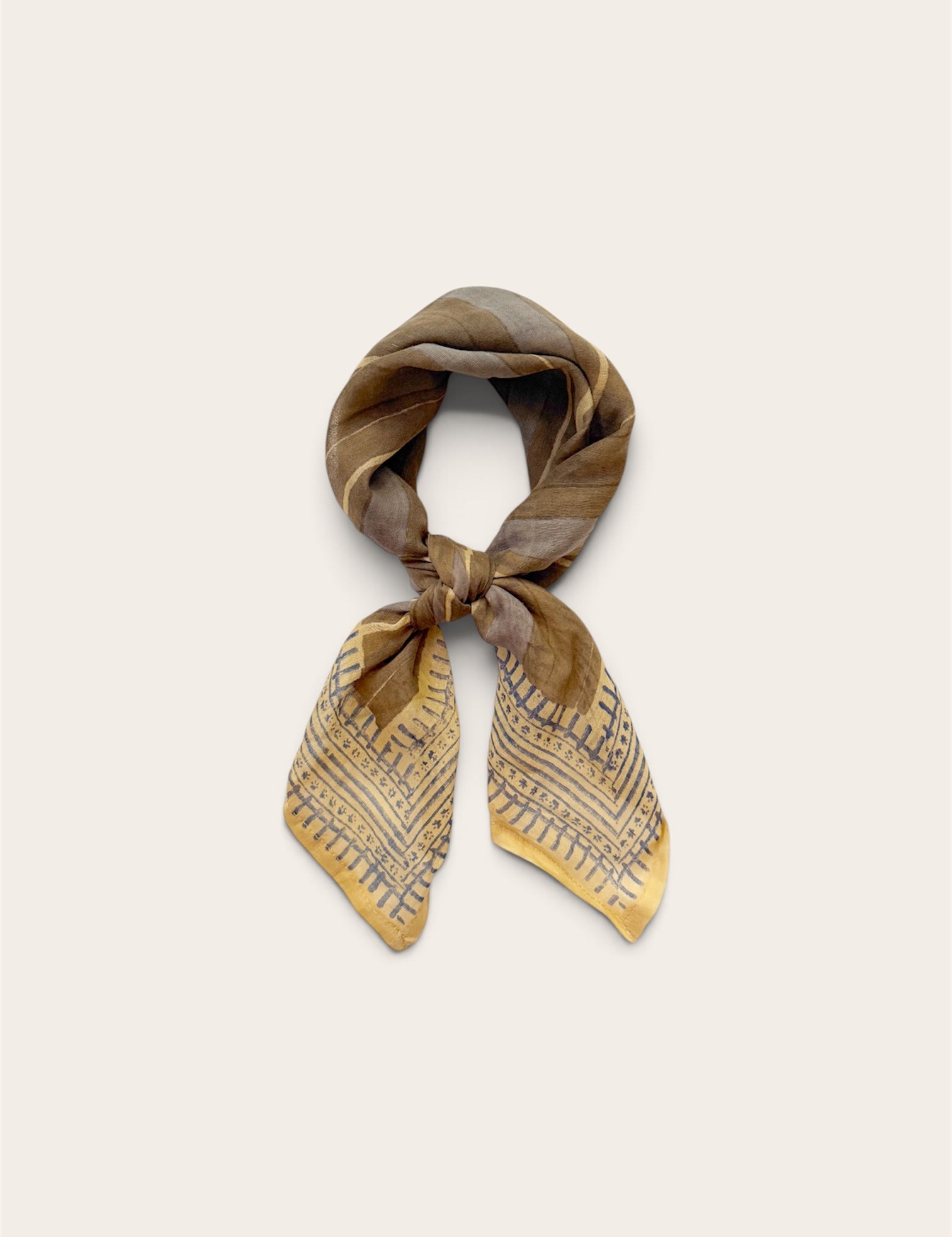 A square cotton scarf tied in a knot, featuring a gray and blue abstract pattern with fine blue lines, displayed on a light beige background.