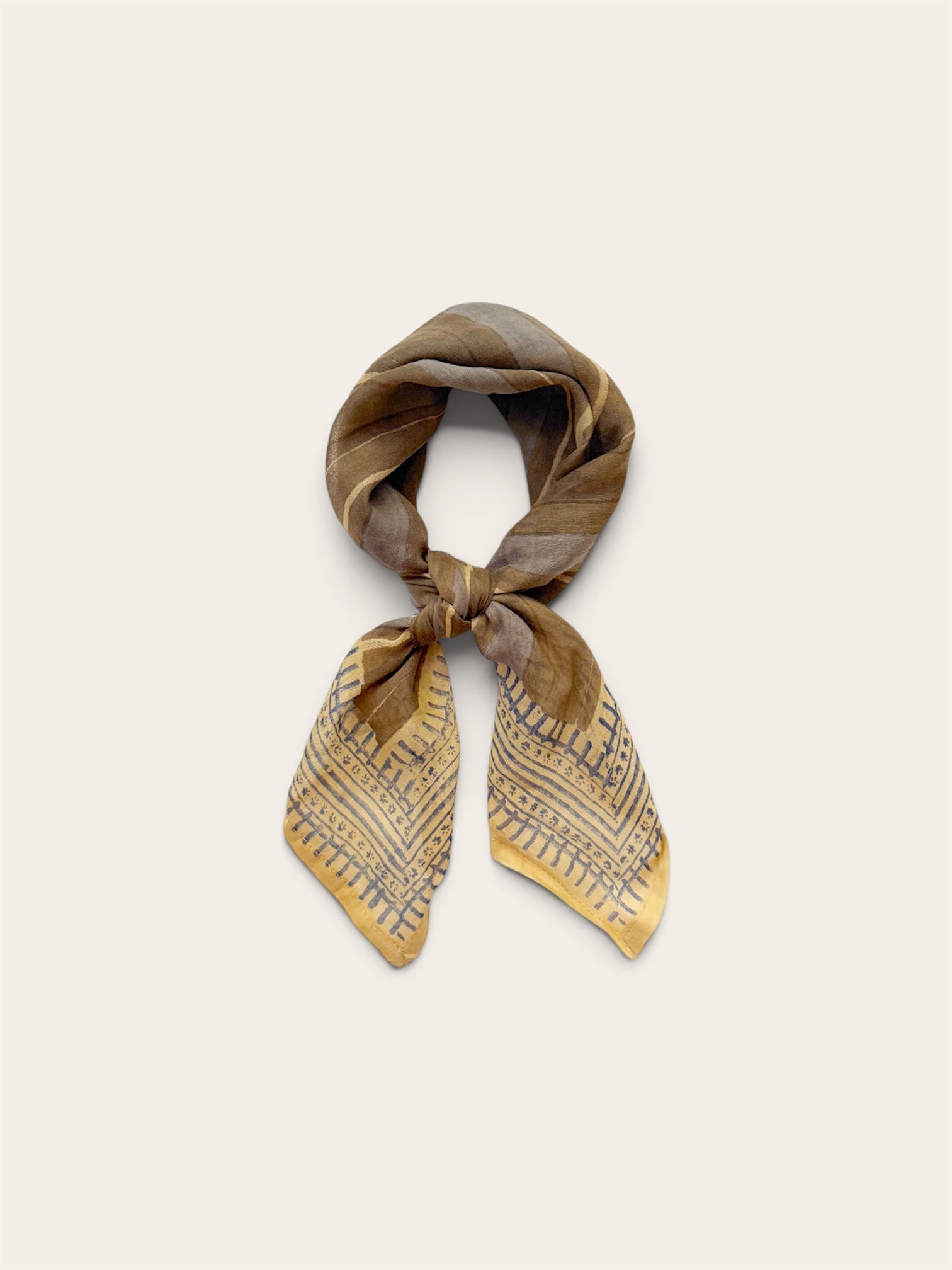 A square cotton scarf tied in a knot, featuring a gray and blue abstract pattern with fine blue lines, displayed on a light beige background.