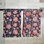 Block printed rose floral hand towels hanging on a shower rod