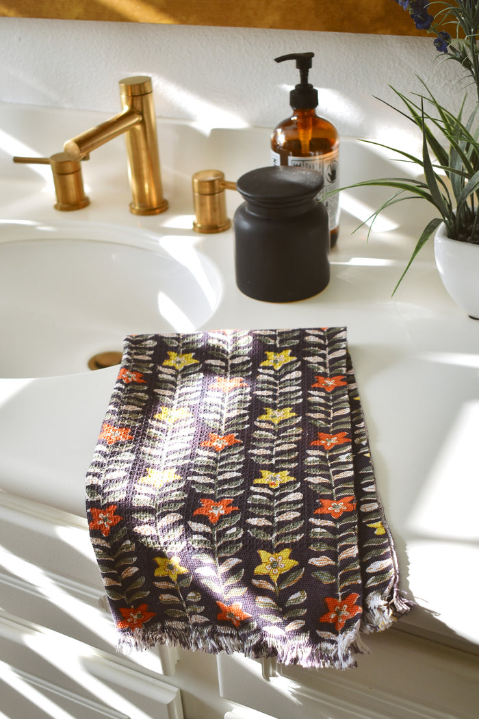 One Selena block printed hand towel folded and placed on a white bathroom counter