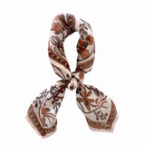 Patterned scarf with brown and beige floral design tied on a white background