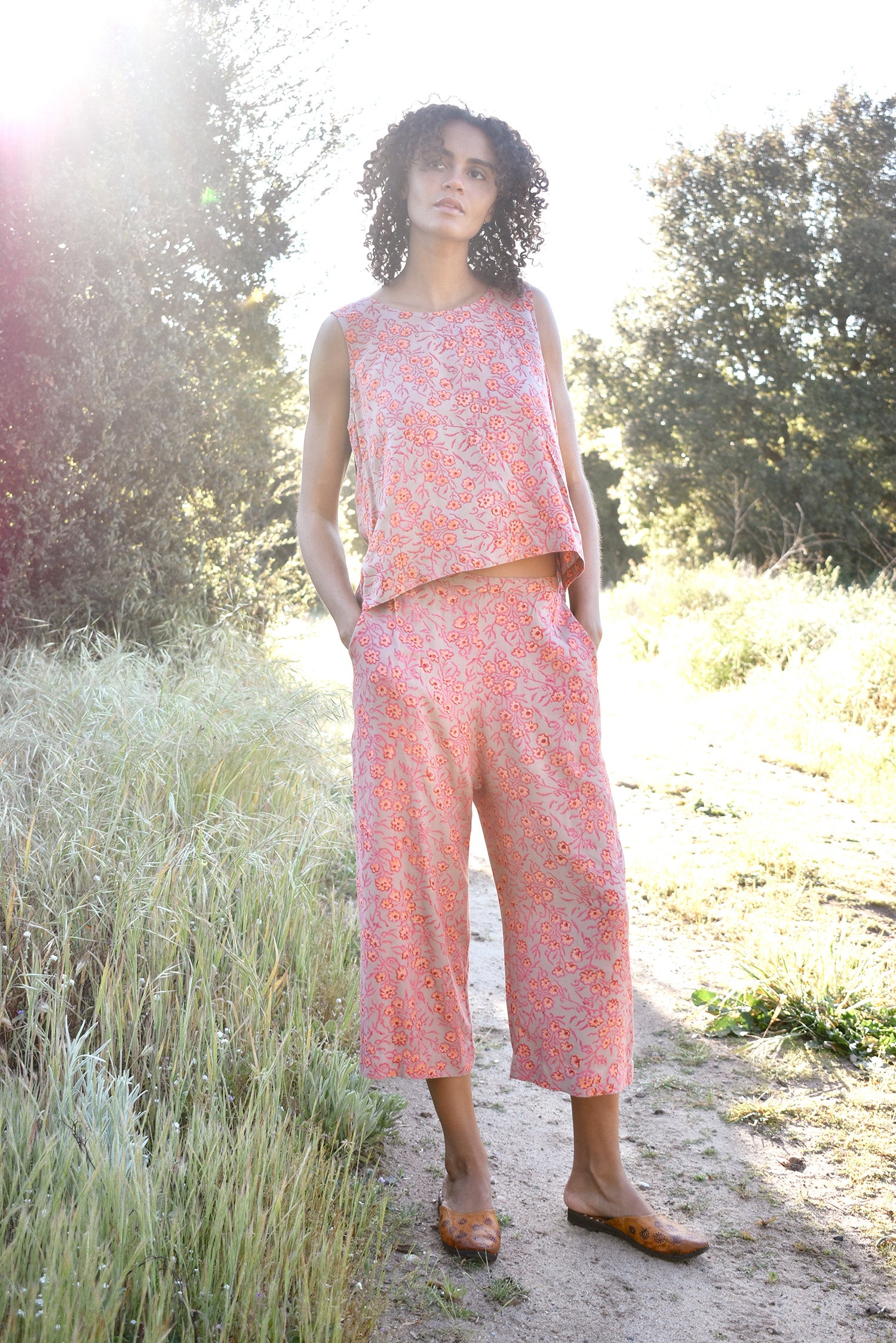 Woman wearing Birkin Set, standing outside with trees in the background