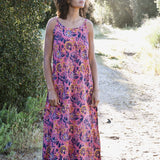 Woman wearing pink and purple floral printed strap maxi dress outside in nature