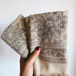 Hand holding textured beige and brown towels against a white background