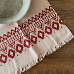 Hand towel with red geometric pattern on a wooden surface