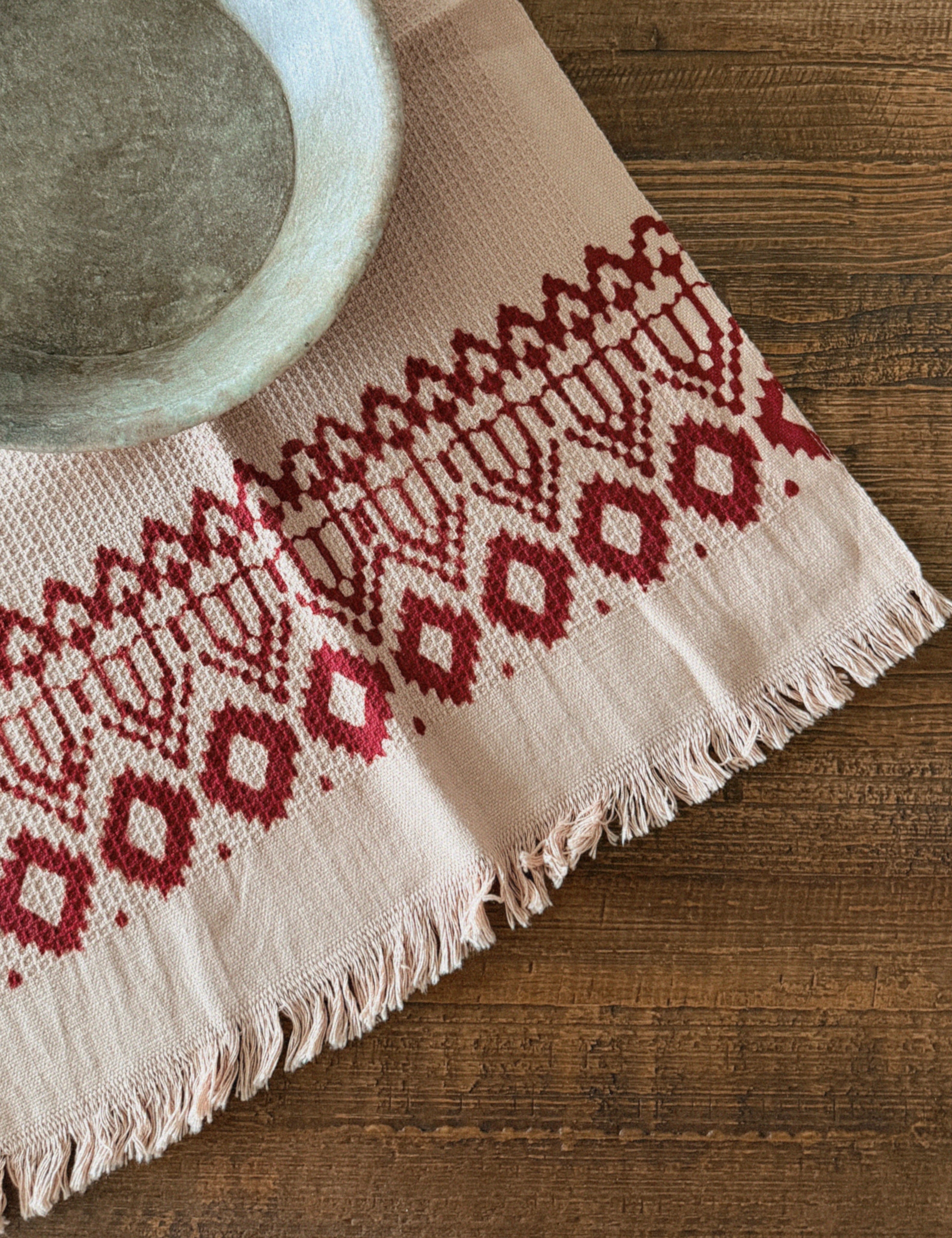 Hand towel with red geometric pattern on a wooden surface