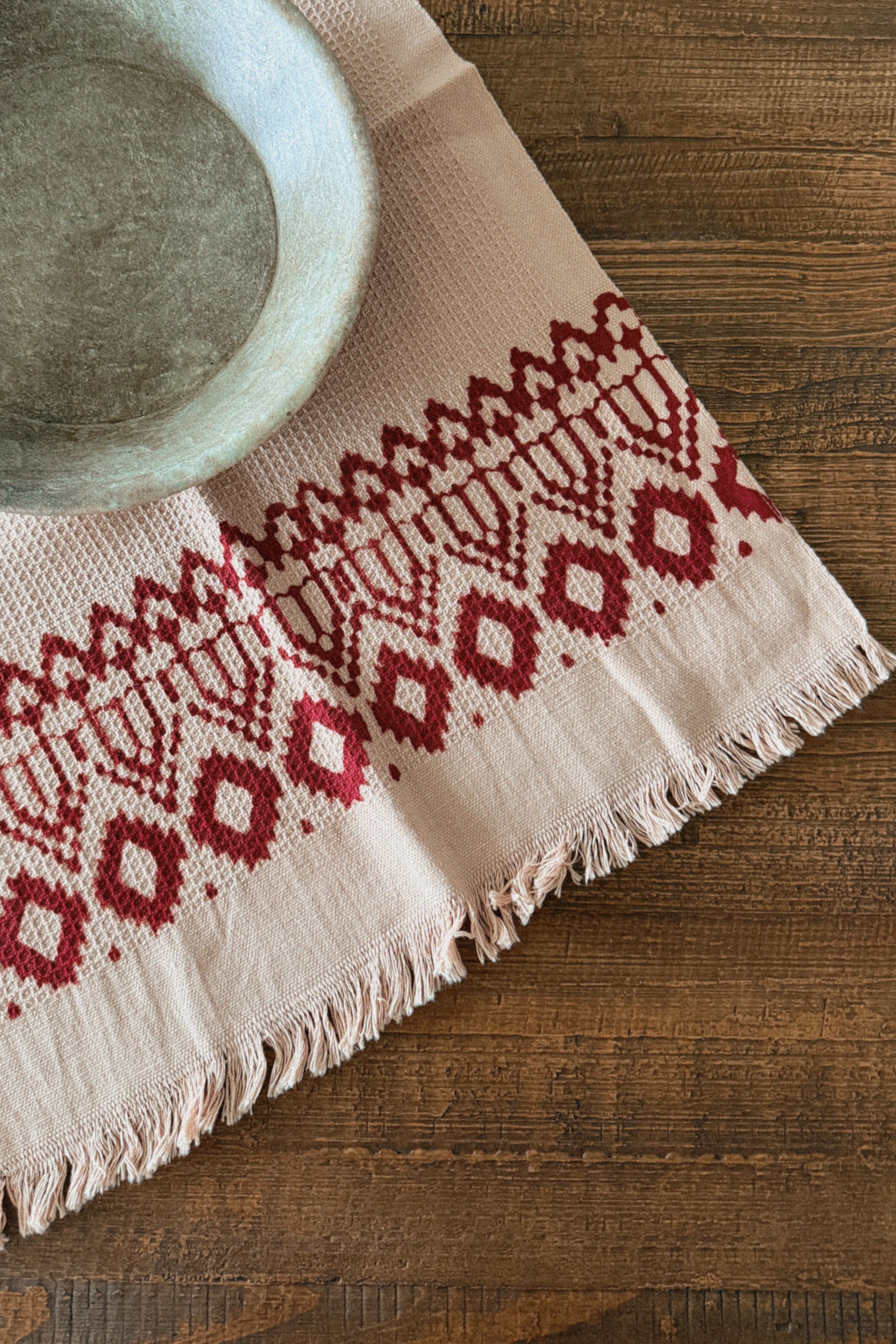 Hand towel with red geometric pattern on a wooden surface
