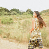 Woman wearing floral block printed sleeveless ruffle dress, back shot