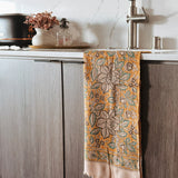 Decorative towel with floral pattern hanging on a kitchen cabinet