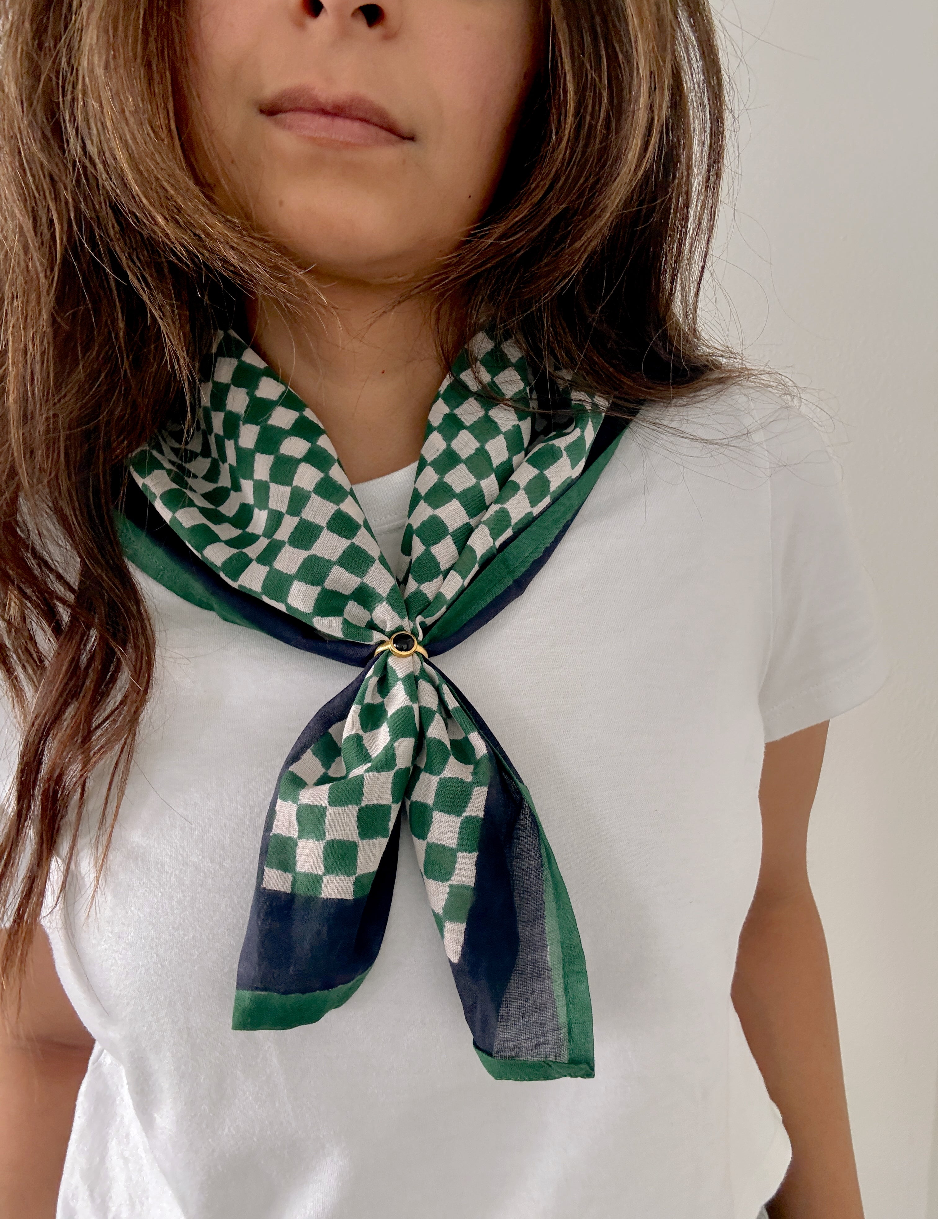 Person wearing a green and white checkered scarf on a plain background