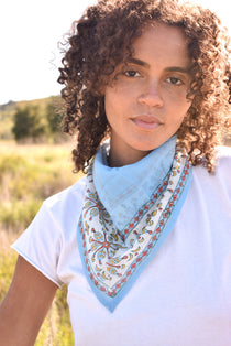 Woman wearing block print Corfu bandana tied around neck against a white tee shirt. 