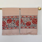 Block printed Rosebud hand towels, hanging on a golden rod. Towels have a rose border print.