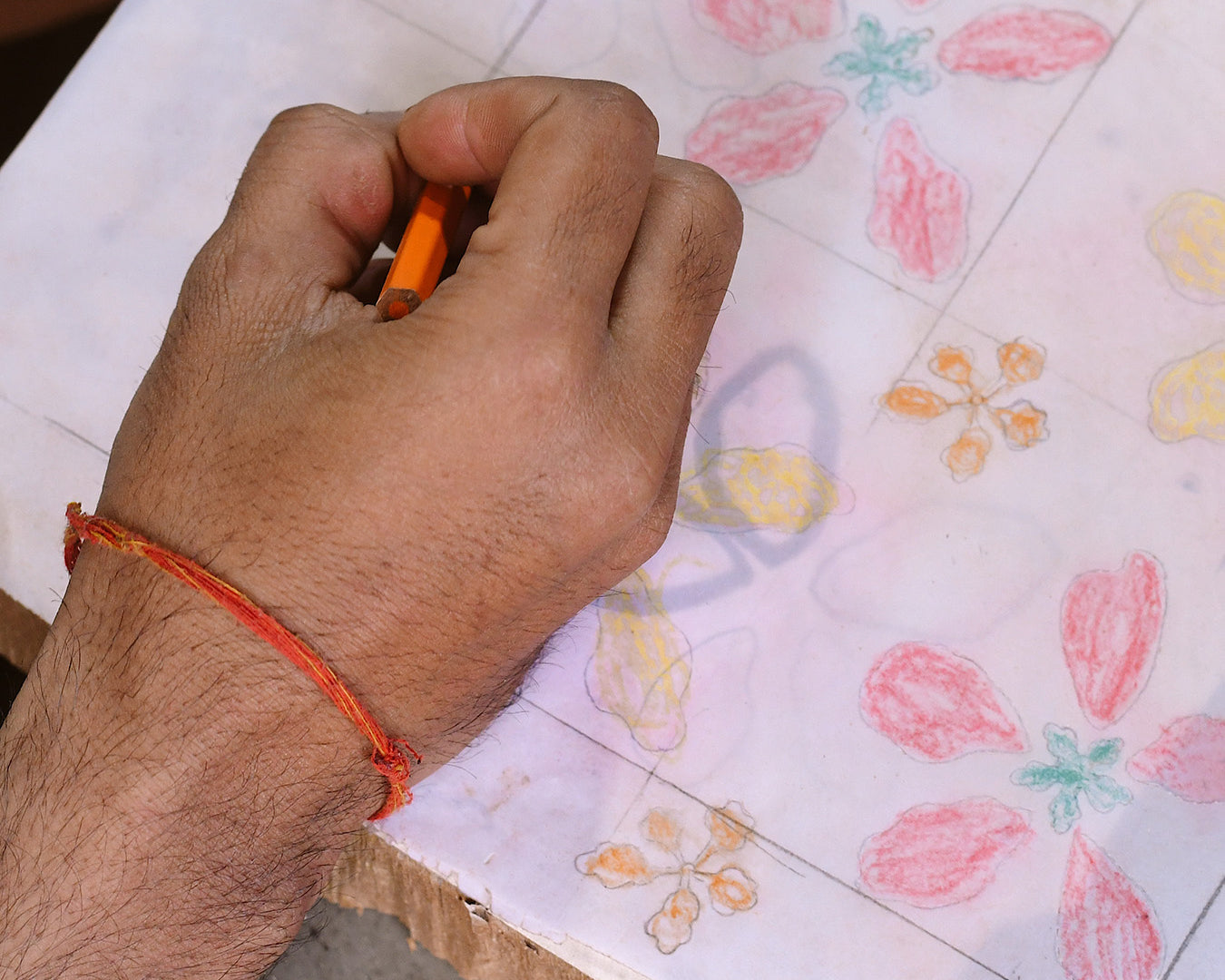 Artist drawing out flowers on transparent paper