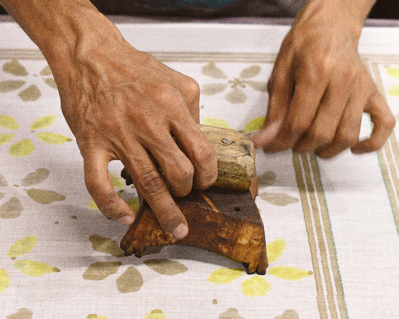 Artist wood block printing flowers onto cotton fabric